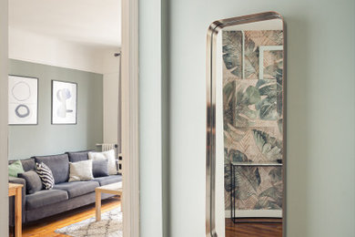Ejemplo de distribuidor minimalista de tamaño medio con paredes verdes, suelo de madera en tonos medios, puerta simple, puerta blanca y suelo beige