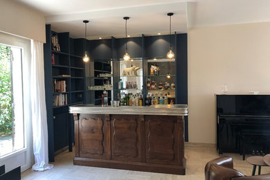 This is an example of a contemporary l-shaped seated home bar in Paris with zinc benchtops.