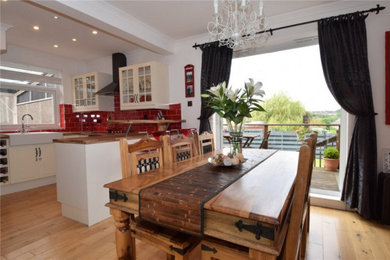 Photo of a modern dining room in Glasgow with red walls and medium hardwood floors.