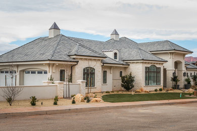 Photo of an expansive transitional two-storey white exterior in Salt Lake City with stone veneer and a hip roof.