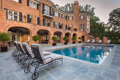 Inspiration for a huge traditional partial sun backyard stone landscaping in DC Metro.