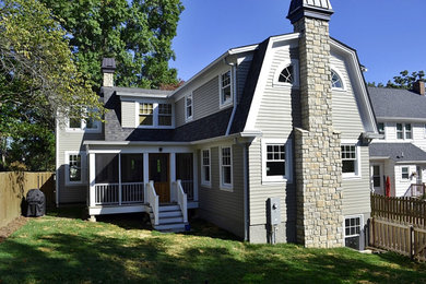 This is an example of a mid-sized traditional three-storey grey house exterior in St Louis with mixed siding, a gambrel roof and a shingle roof.