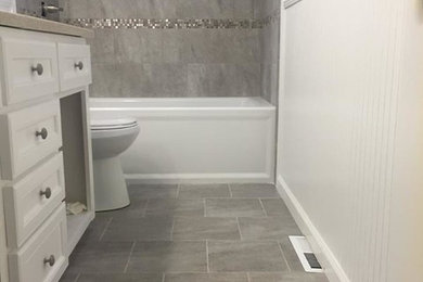 Inspiration for a mid-sized transitional gray tile and porcelain tile porcelain tile and gray floor bathroom remodel in Other with recessed-panel cabinets, white cabinets, an undermount sink and gray walls