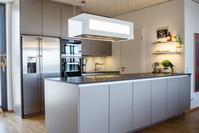 This is an example of a scandinavian open plan kitchen in Cologne with with island.