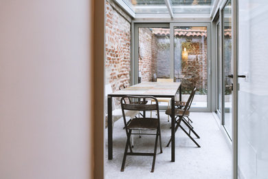 Idee per una veranda contemporanea con pavimento in pietra calcarea, soffitto in vetro e pavimento grigio