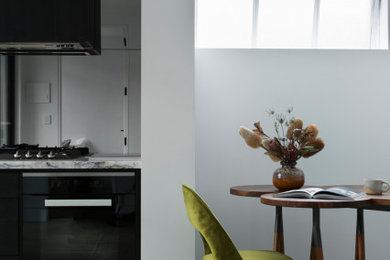 This is an example of a small urban single-wall open plan kitchen in Melbourne with a submerged sink, all styles of cabinet, black cabinets, marble worktops, black splashback, glass sheet splashback, stainless steel appliances, concrete flooring, no island, grey floors and multicoloured worktops.