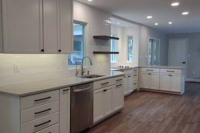 Inspiration for a mid-sized transitional brown floor kitchen remodel in DC Metro with an undermount sink, shaker cabinets, white cabinets, quartz countertops, white backsplash, ceramic backsplash, stainless steel appliances and multicolored countertops