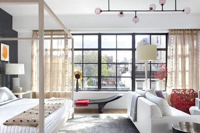 Example of a large trendy master light wood floor bedroom design in New York with white walls and a standard fireplace
