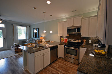 Open concept kitchen - coastal u-shaped medium tone wood floor open concept kitchen idea in Charleston with beaded inset cabinets, white cabinets, granite countertops and stainless steel appliances