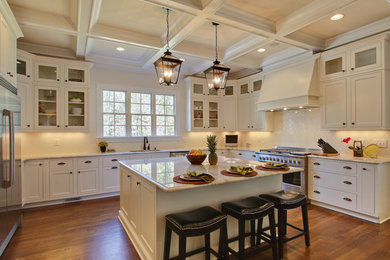 Elegant u-shaped kitchen photo in Raleigh with shaker cabinets, white cabinets, white backsplash and stainless steel appliances