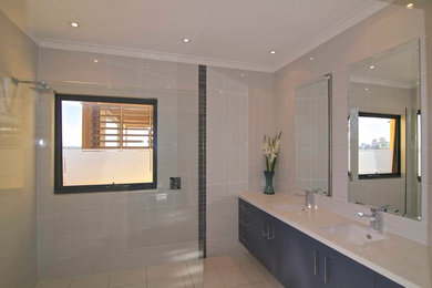 Mid-sized modern master bathroom in Perth with an undermount sink, flat-panel cabinets, blue cabinets, engineered quartz benchtops, an open shower, a one-piece toilet, white tile, ceramic tile, white walls and ceramic floors.