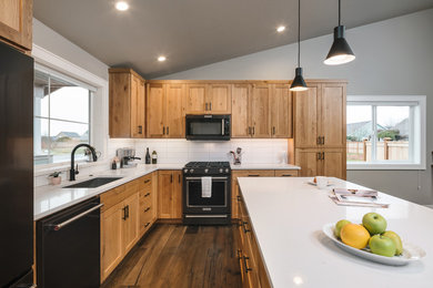 Kitchen - mid-sized transitional l-shaped medium tone wood floor and brown floor kitchen idea in Portland with an undermount sink, white backsplash, porcelain backsplash, black appliances, white countertops, shaker cabinets, light wood cabinets, quartz countertops and an island