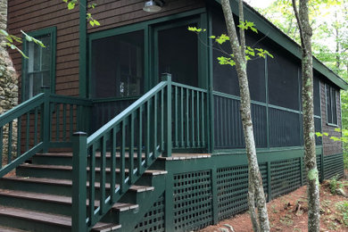 Photo of a medium sized classic front screened wood railing veranda in Portland Maine with a roof extension.