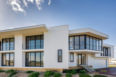 Two-storey concrete white house exterior in Perth with a flat roof and a grey roof.