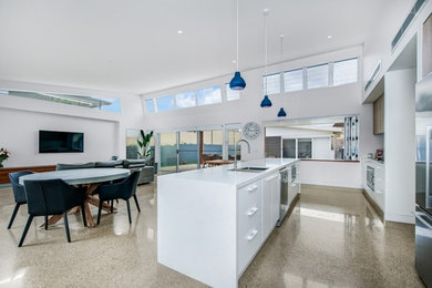 This is an example of a contemporary kitchen in Newcastle - Maitland with a double-bowl sink, recessed-panel cabinets, white cabinets, quartz benchtops, stainless steel appliances, concrete floors, with island and grey floor.