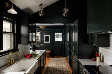 Kitchen - mid-sized traditional medium tone wood floor, yellow floor and exposed beam kitchen idea in Seattle with a farmhouse sink, shaker cabinets, black cabinets, quartzite countertops, gray backsplash, ceramic backsplash, colored appliances, an island and gray countertops