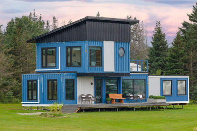 Small modern blue two-story metal tiny house idea in Other with a black roof