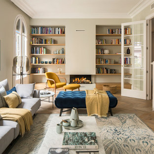 Große, Fernseherlose, Abgetrennte Mediterrane Bibliothek mit beiger Wandfarbe, braunem Holzboden, Kaminofen, verputztem Kaminsims und beigem Boden in Barcelona
