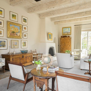 Modelo de salón mediterráneo con paredes beige, chimenea tradicional y suelo marrón