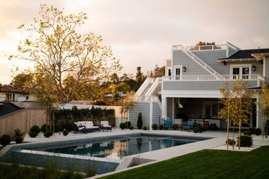 Foto de piscina infinita contemporánea de tamaño medio rectangular en patio trasero con paisajismo de piscina y losas de hormigón