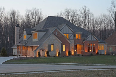 Large traditional gray three-story brick gable roof idea in Cleveland