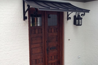 Example of a mid-sized ceramic tile entryway design in New Orleans with white walls and a dark wood front door