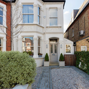 Exempel på ett mellanstort klassiskt vitt flerfamiljshus, med tre eller fler plan