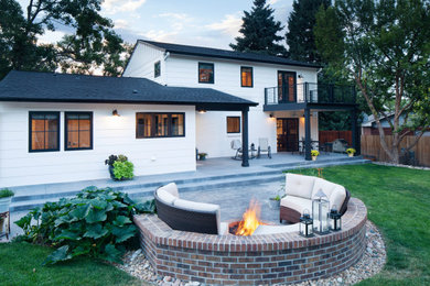 This is an example of a country two-storey white house exterior in Denver with concrete fiberboard siding, a gable roof and a shingle roof.