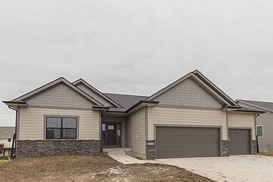 Example of a mid-sized transitional beige one-story concrete fiberboard gable roof design in Other