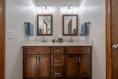 Example of a mid-sized transitional multicolored tile and porcelain tile vinyl floor, brown floor and double-sink bathroom design in Cleveland with shaker cabinets, dark wood cabinets, a two-piece toilet, an undermount sink, quartz countertops, a hinged shower door, beige countertops and a built-in vanity