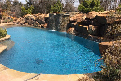 Hot tub - large tropical backyard custom-shaped natural hot tub idea in Oklahoma City
