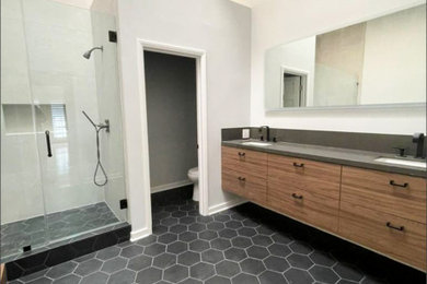 Bathroom - large modern master ceramic tile, black floor and double-sink bathroom idea in Los Angeles with flat-panel cabinets, medium tone wood cabinets, white walls, granite countertops, a hinged shower door, gray countertops and a floating vanity