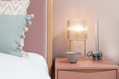 This is an example of a medium sized contemporary guest bedroom in Oxfordshire with pink walls, carpet, beige floors, wallpapered walls and feature lighting.