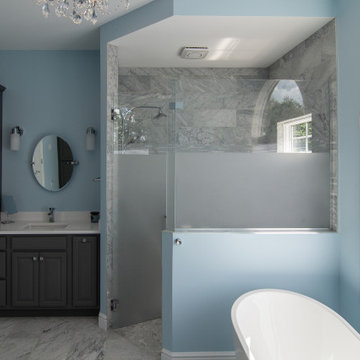 Traditional master bath utilizing frosted and clear glass to allow for needed pr