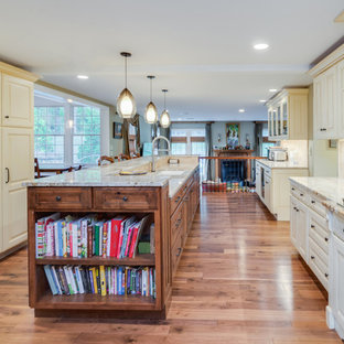 Photo of a transitional u-shaped kitchen pantry in Philadelphia with raised-panel cabinets, white cabinets, granite benchtops, beige splashback, medium hardwood floors, with island, a drop-in sink and coloured appliances.