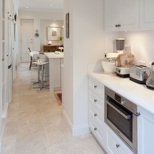 Small farmhouse kitchen pantry appliance - Kitchen pantry - small country galley beige floor kitchen pantry idea in Perth with a drop-in sink, beaded inset cabinets, white cabinets, white backsplash, porcelain backsplash, stainless steel appliances and no island