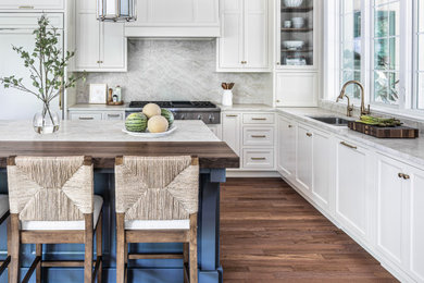 Large transitional l-shaped medium tone wood floor and brown floor eat-in kitchen photo in Philadelphia with a double-bowl sink, shaker cabinets, white cabinets, quartzite countertops, beige backsplash, stone slab backsplash, paneled appliances, an island and beige countertops