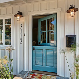 Esempio di una porta d'ingresso costiera di medie dimensioni con una porta olandese, una porta blu, pareti bianche e pavimento in pietra calcarea