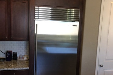 Mid-sized elegant l-shaped kitchen photo in Sacramento with granite countertops, beige backsplash, ceramic backsplash, stainless steel appliances and an island
