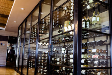 Inspiration for a large light wood floor wine cellar remodel in Austin with storage racks