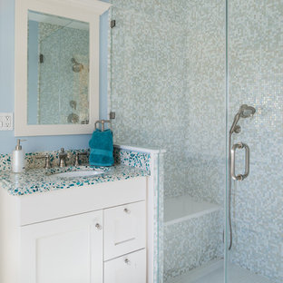 Cette photo montre une petite salle de bain chic avec un lavabo encastré, un placard à porte shaker, des portes de placard blanches, un carrelage multicolore, carrelage en mosaïque, un mur bleu, un sol en carrelage de porcelaine, un plan de toilette en verre recyclé et un plan de toilette multicolore.