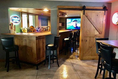 Esempio di un grande angolo bar stile rurale con ante in stile shaker, ante in legno scuro, top in legno, pavimento in cemento e pavimento multicolore