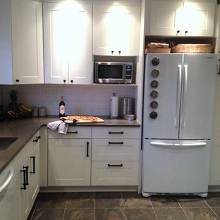 Mid-sized farmhouse kitchen pantry photos - Mid-sized country l-shaped porcelain floor kitchen pantry photo in Montreal with a drop-in sink, raised-panel cabinets, white cabinets, quartzite countertops, white backsplash, subway tile backsplash and white appliances