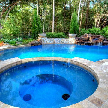 Natural Pool with rock waterfall, bridge, spa, and pergola