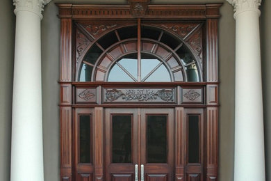 Example of a huge tuscan concrete floor entryway design in Edmonton with gray walls and a dark wood front door