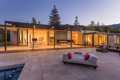 Large trendy backyard concrete paver patio fountain photo in San Francisco with a roof extension