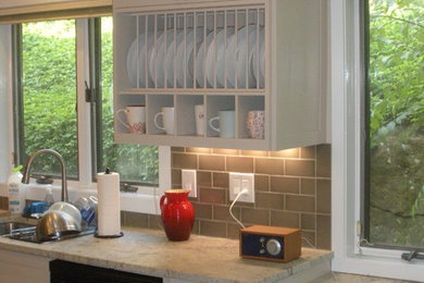 Example of a mid-sized transitional u-shaped medium tone wood floor and brown floor eat-in kitchen design in New York with an island, shaker cabinets, white cabinets, a double-bowl sink, granite countertops, gray backsplash, subway tile backsplash and stainless steel appliances