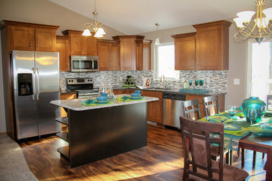 Example of a large classic l-shaped medium tone wood floor and brown floor eat-in kitchen design in Other with a double-bowl sink, recessed-panel cabinets, medium tone wood cabinets, laminate countertops, multicolored backsplash, ceramic backsplash, stainless steel appliances and an island