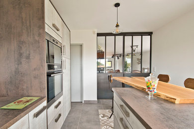 Exemple d'une grande cuisine américaine encastrable industrielle en bois clair avec un évier posé, un placard à porte plane, un plan de travail en stratifié, une crédence grise, une crédence en dalle métallique, un sol en carrelage de céramique, îlot et un sol beige.