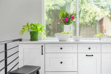Inspiration for a small timeless galley light wood floor and brown floor enclosed kitchen remodel in Seattle with an undermount sink, shaker cabinets, white cabinets, quartz countertops, gray backsplash, glass tile backsplash, stainless steel appliances, no island and white countertops